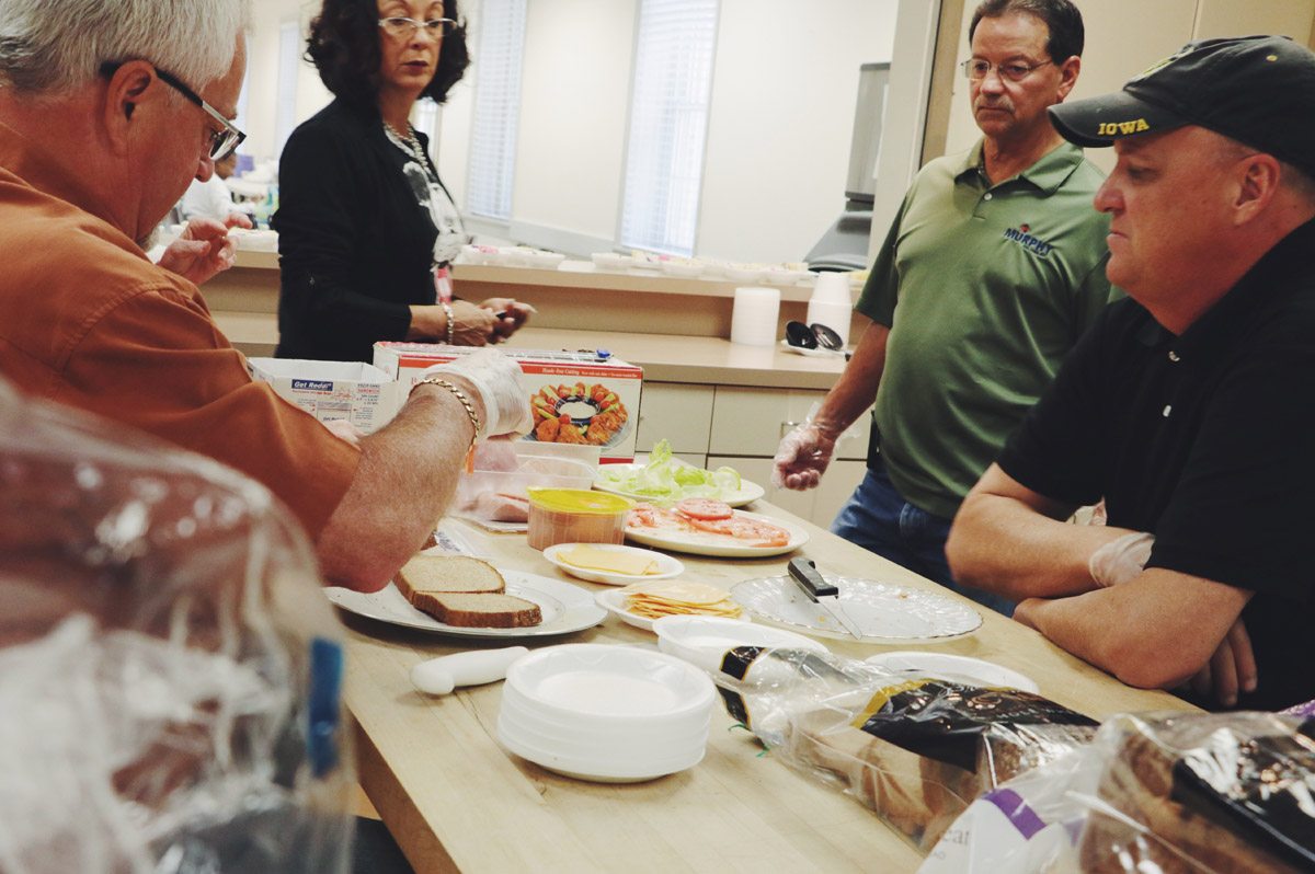 Volunteers preparing sandwiches together at the serving counter